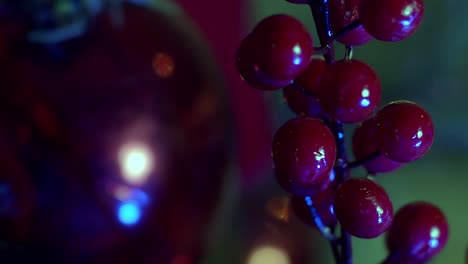 Dekorativer-Weihnachtsschmuck-Aus-Roten-Beeren-Aus-Kunststoff,-Während-Weihnachtslichter-Funkeln