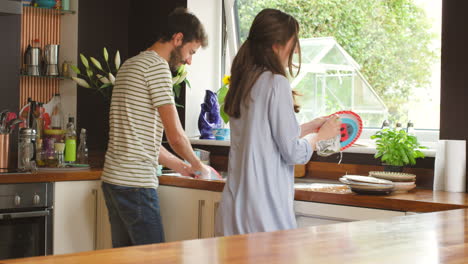 A-happy-couple-dancing-and-cleaning-dishes