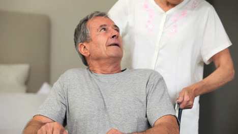 mature woman talking with husband in wheelchair