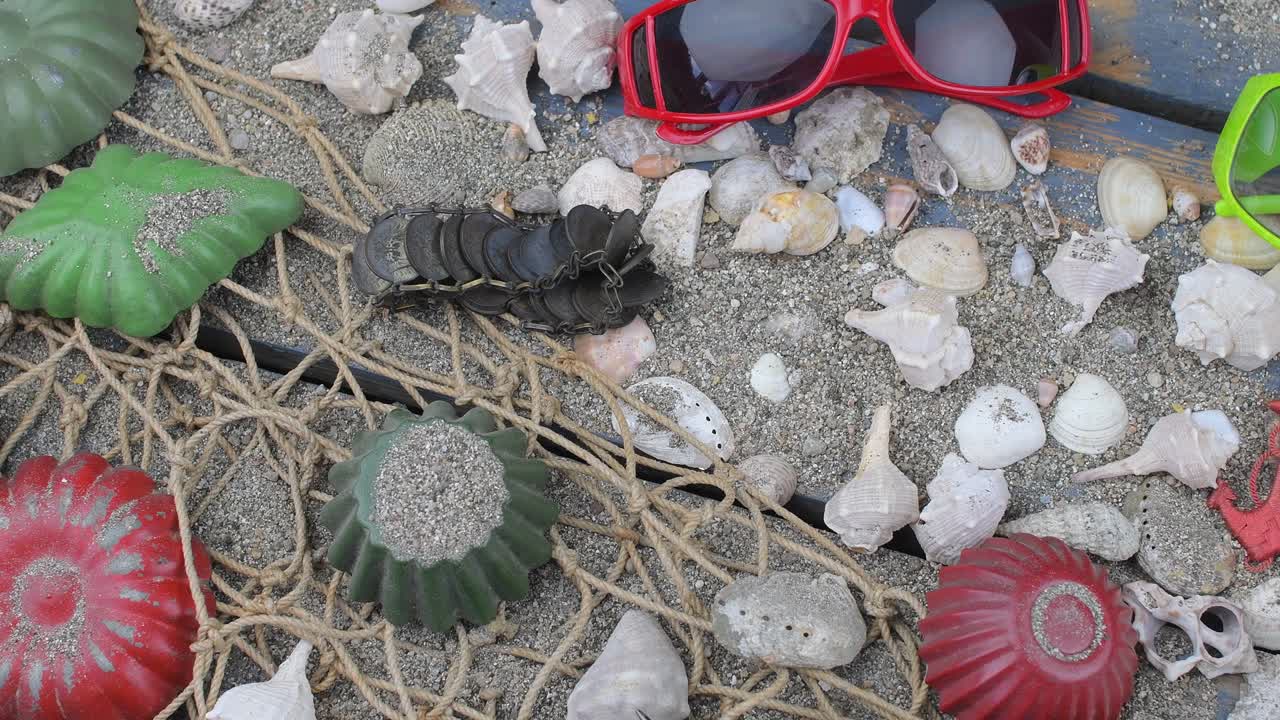 conchas marinas en un fondo azul. tiempo de viaje de verano. fondo de vacaciones en el mar con varias conchas, gafas de sol y cámara vintage. diseño de colocación. vista superior. colocación plana