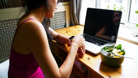 Mujer-Sentada-A-La-Mesa-Y-Usando-Reloj-Inteligente