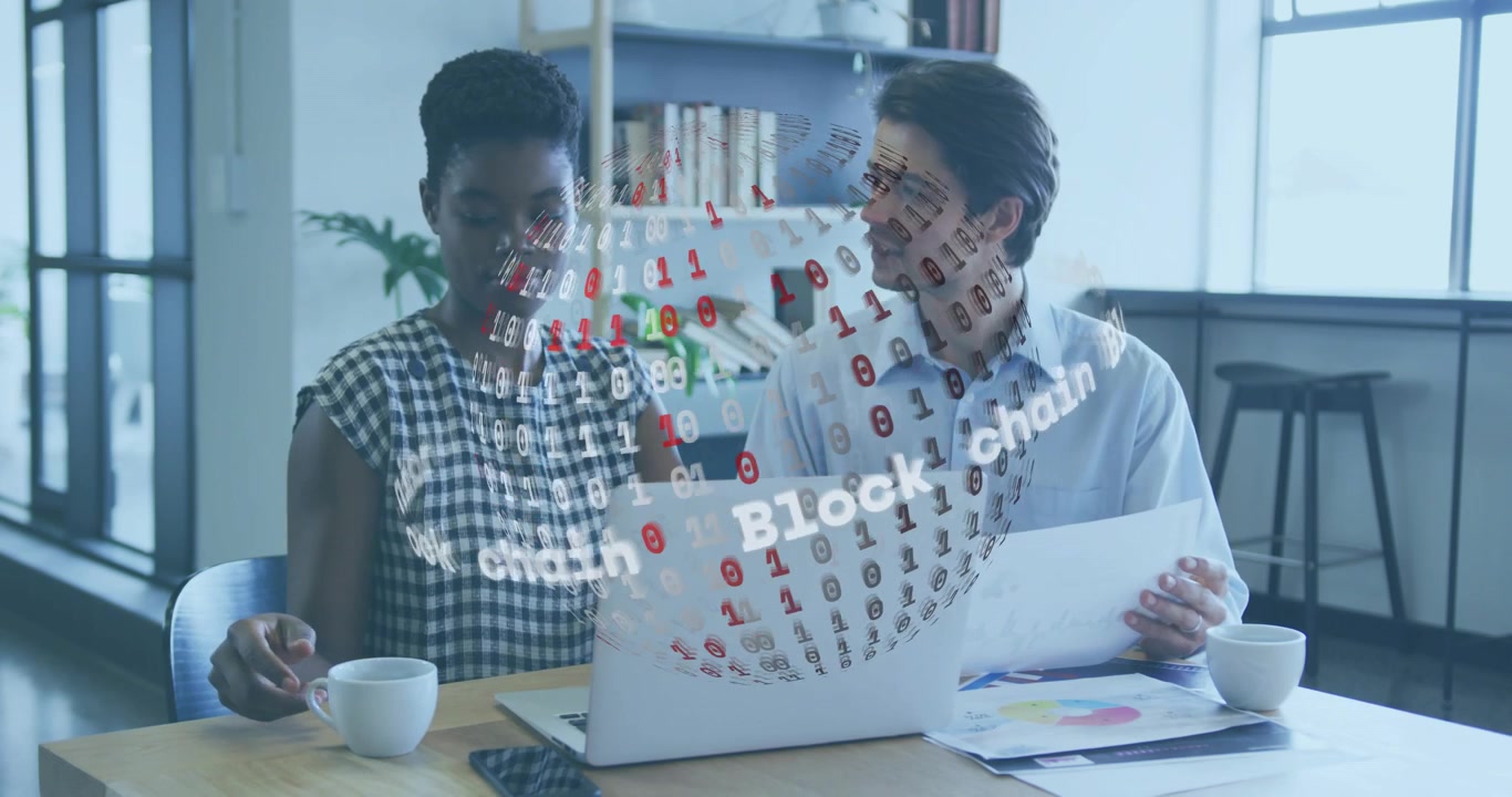 ノートパソコンを指す女性とチャートを持つ男性が、データ分析中にブロックチェーンホログラムを起動している。