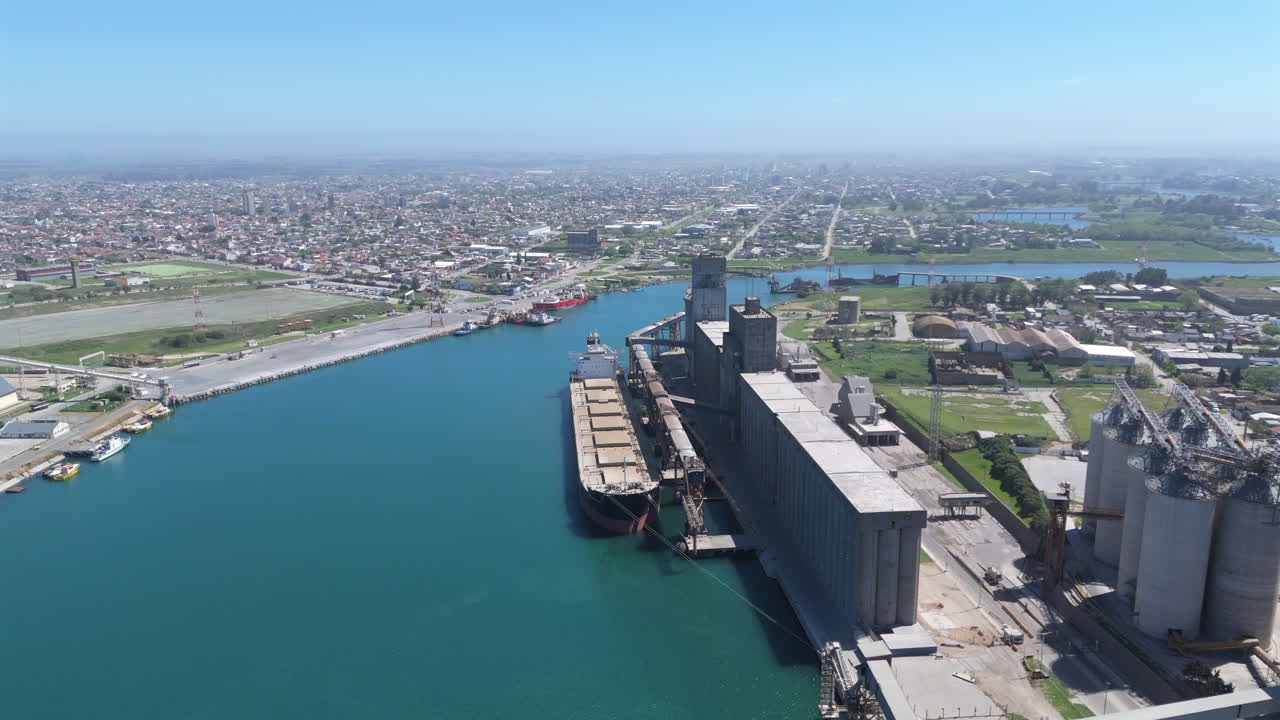 Wide angle drone footage capturing the bustling Port of Necochea, Argentina. Highlights industrial activity, cargo ships, and the surrounding coastal environment in vivid detail.