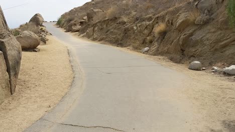 Reveal-shot-of-hiking-road-between-rocks-in-mountains-Southern-California