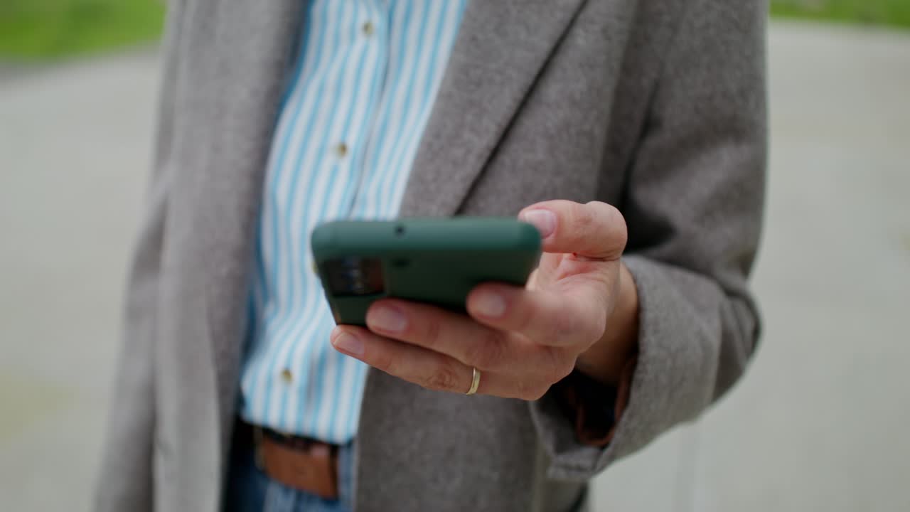 밖에서 스마트폰을 사용하는 여성