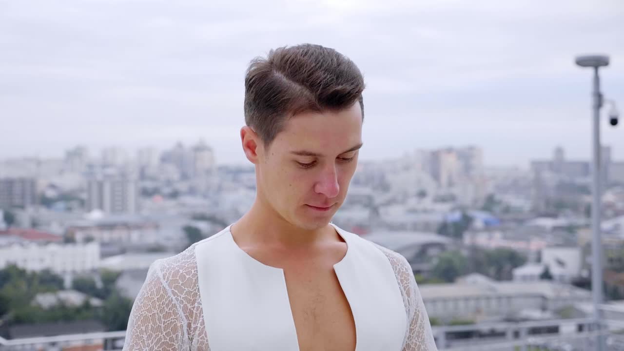 Man in White Outfit on Rooftop