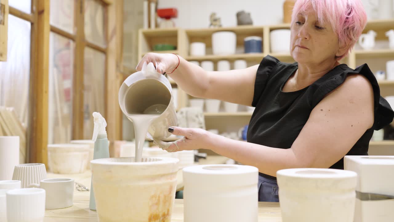 Woman Pouring Glaze on Pottery