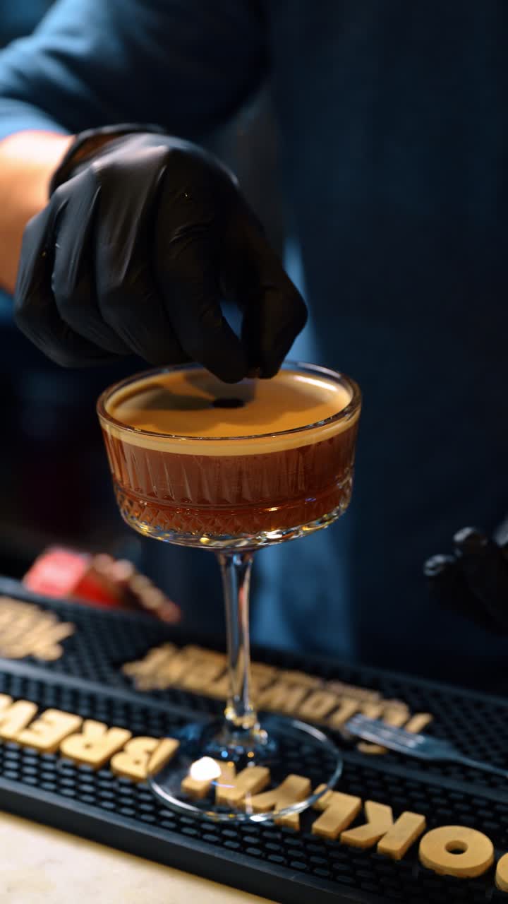 New York, USA, 15 aprile 2026: Cocktail Espresso Martini in un bicchiere a coppa con chicco di caffè. Cocktail al caffè pronto con schiuma densa e guarnizione, appoggiato su un tappetino da bar in gomma.