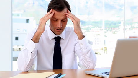 Businessman-rubbing-temples-and-looking-worried