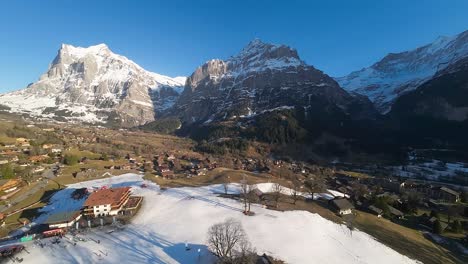 Vista-Aérea-Ascendente-De-La-Estación-De-Esquí-Del-área-De-Grindelwald-En-Los-Alpes-Suizos.