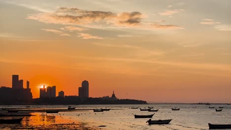 vista del atardecer con barcos y el horizonte de la ciudad