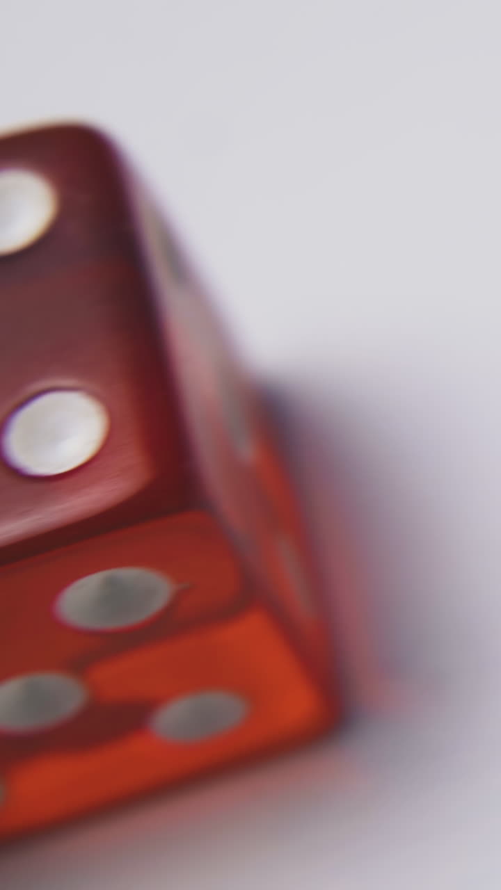 motion over bright red transparent dices with spots on top sides on light background extreme close view