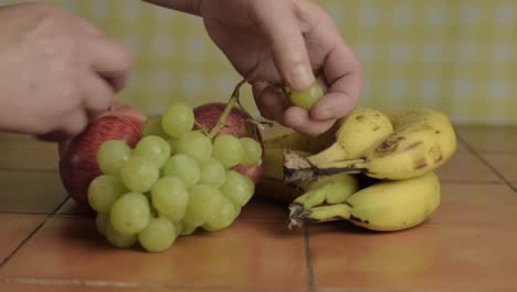 recogiendo uvas a mano de una selección de frutas de plano medio.