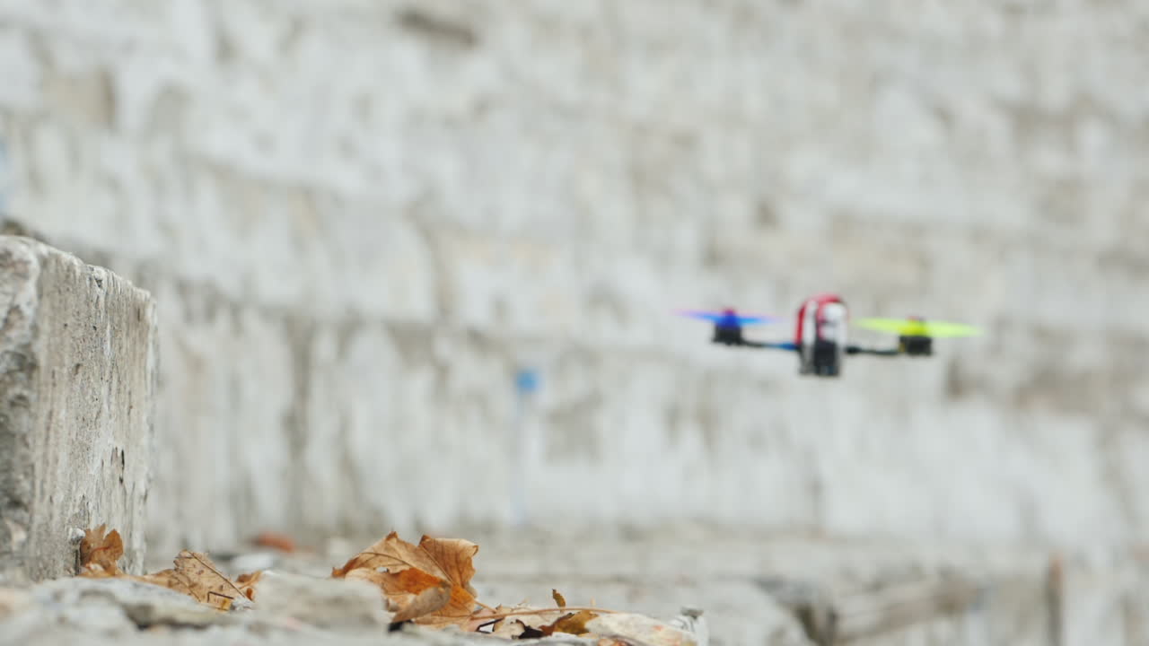 無人機快速飛行,在地面上空低,在風中從地面抬起葉子