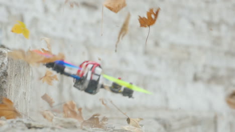 the drone flies quickly and low above the ground lifting leaves from the ground in the wind