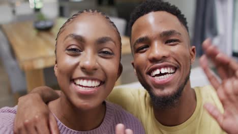 happy african american couple talking to camera during video call