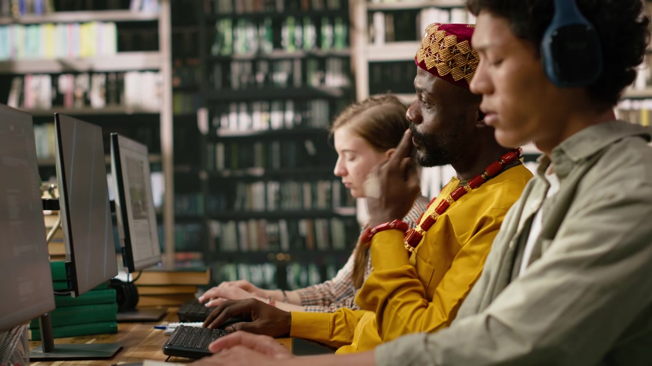 African man student working at desktop computer and wearing traditional clothes