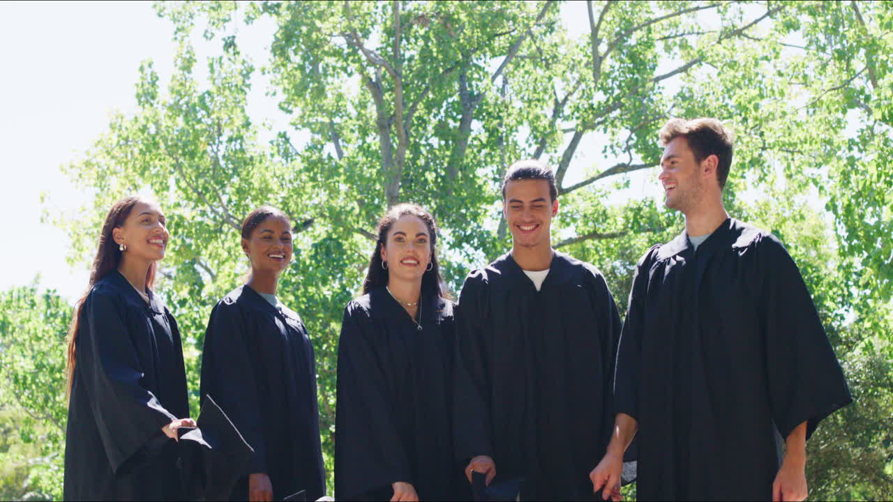 행복 한 학생 들 이 공중 에 모자 를 던지고 있다