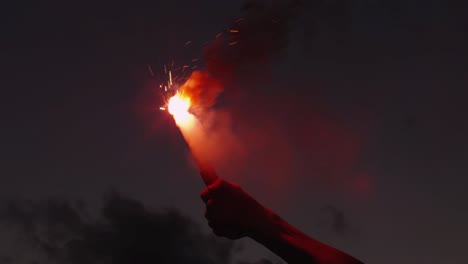 close-up shot of hand holding red signal flare