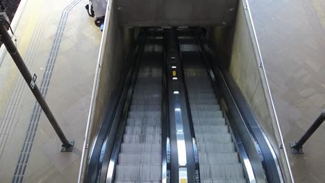 un alto ángulo de visualización de una escalera mecánica en movimiento vacía, llegando al metro