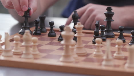 close of chess board with hands of a young man