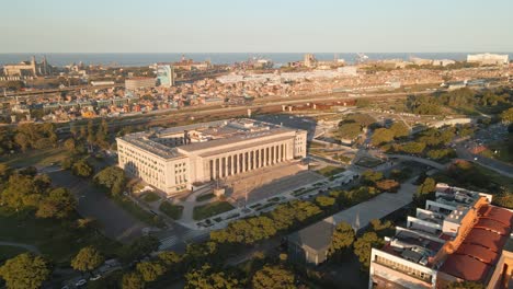 aerial parallax shot of the faculty of law of university of buenos aires and villa 31 at golden hour