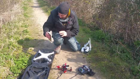 male packing away drone after flying, putting equipment into safety backpack