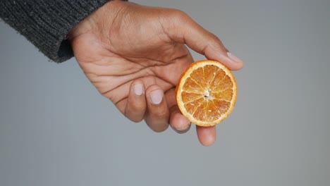 hand holding a dried orange slice