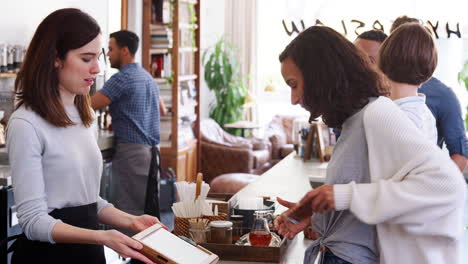 Young-customers-queuing-to-order-and-pay-at-a-coffee-shop