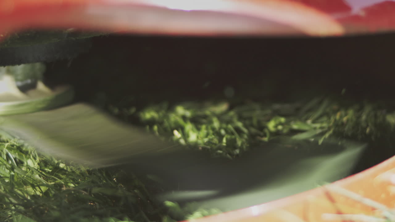 крупный взгляд на газонокосилку, вырезающую траву