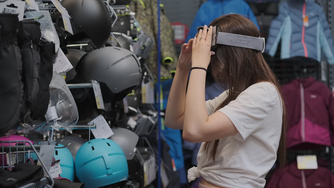 스포츠 상점 에서 스키 안경 과 헬 을 착용 하는 여자