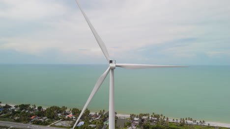 tropical beach town ocean with wind turbine on coastal area