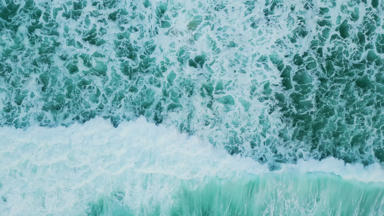 Aerial marine view turquoise ocean waves washing sand shore in super slow motion