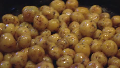 Close-up-shot-of-small-potatoes-being-cooked-in-a-pan