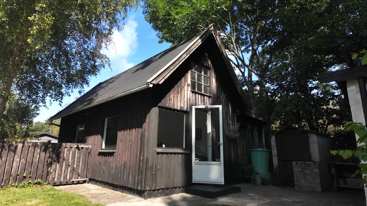 Rustic, dark wood cabin or summer house in the countryside of Denmark