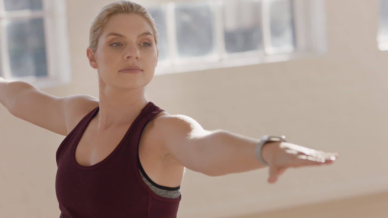 hermosa joven caucásica practicando yoga guerrero pose instructor de entrenamiento mostrando postura guiando la clase de fitness en el estudio