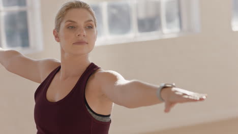 beautiful-young-caucasian-woman-practicing-yoga-warrior-pose-workout-instructor-showing-posture-guiding-fitness-class-in-studio