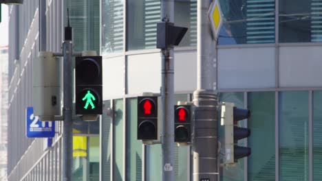 tres semáforos en un cruce de peatones cambiando de color en una fila