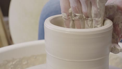 skillful artisan making argil pot on potter wheel