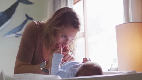 video of happy caucasian mother changing newborn baby