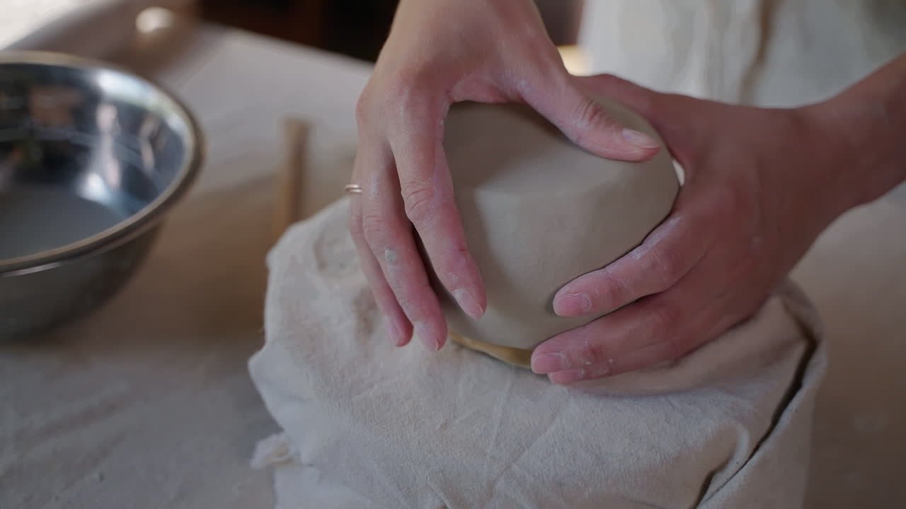mujer formando un cuenco de arcilla