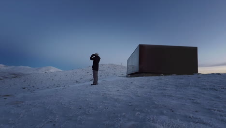 Hombre-Con-Binoculares-Viendo-Paisajes-Distantes-Desde-Un-Paisaje-Nevado-Fuera-De-Su-Casa