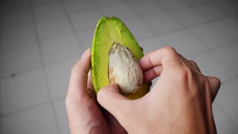 oval-shaped single large seed surrounded by creamy green fruit flesh