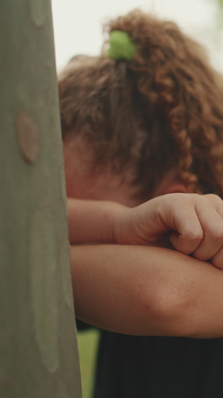 Un bambino triste appoggiato a un palo