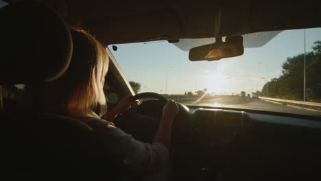 Middle-aged-female-driver-drives-car-in-setting-sun-3