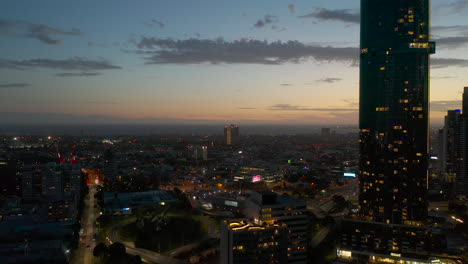 Aerial-decent-over-Southbank,-Melbourne,-Australia-looking-towards-the-gorgeous-Port-Phillip-Bay-during-dusk