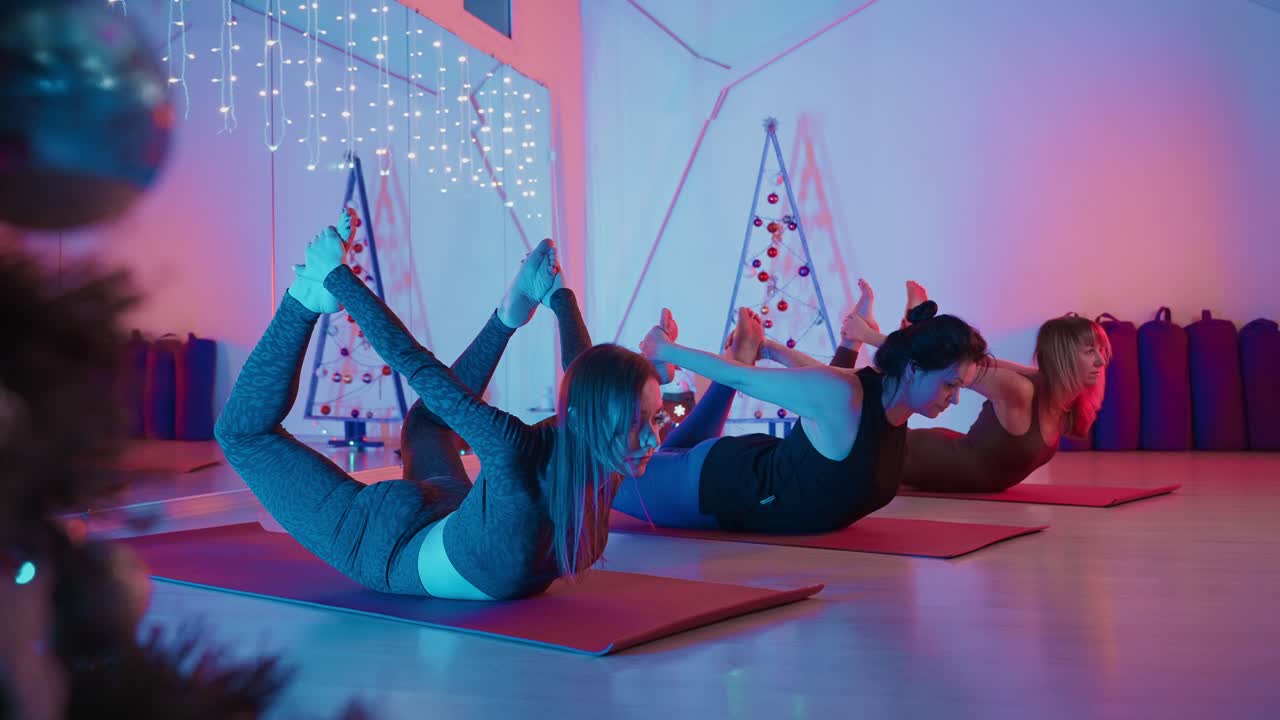 Women Practicing Yoga in a Studio During the Holidays