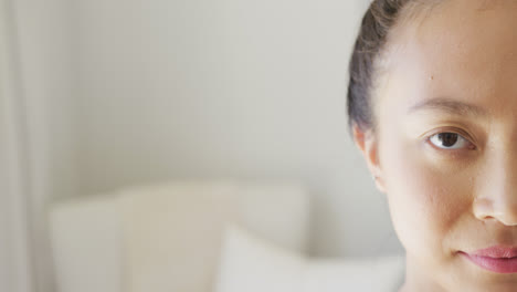 Portrait-of-happy-asian-woman-smiling-in-bedroom,-with-copy-space,-in-slow-motion