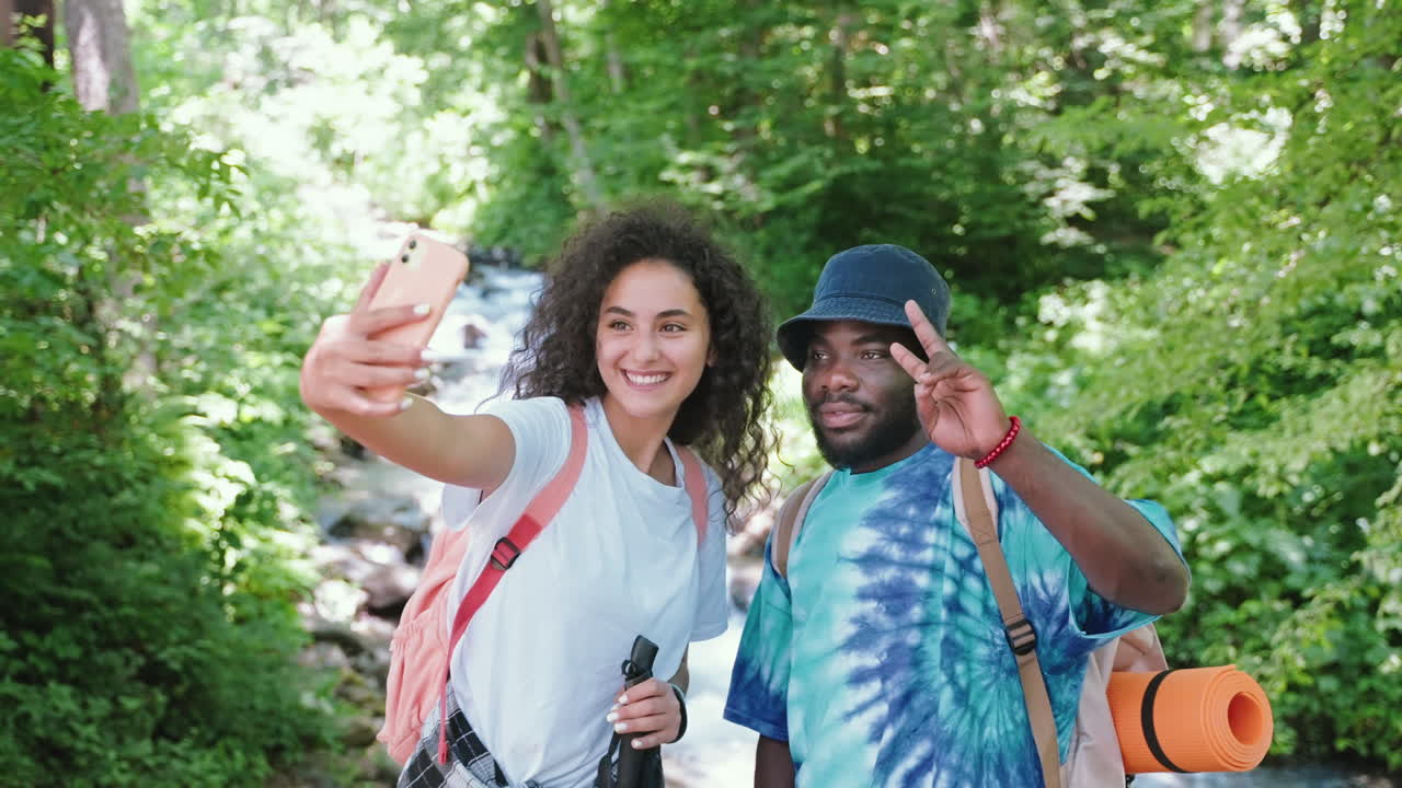 una pareja feliz tomando una selfie en un bosque