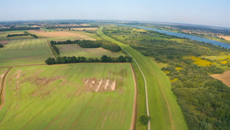 Luftaufnahme-Einer-Drohne,-Die-über-Dem-Ackerlandfluss-Im-Hintergrund-Fliegt